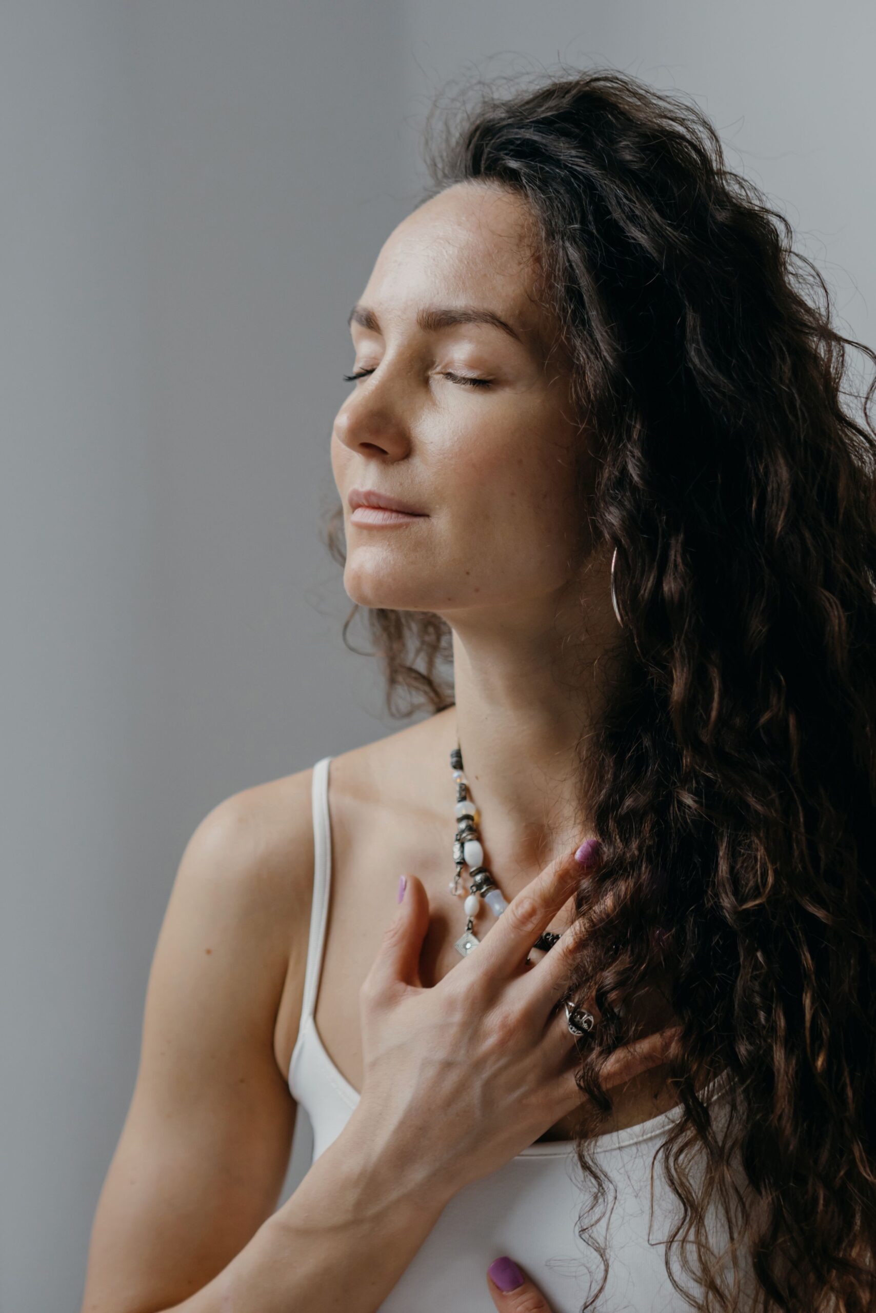 Femme paisible, yeux fermés, main sur le coeur, écoutant son corps